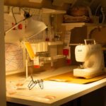 Beleuchteter Arbeitstisch mit Nähmaschine und Bastelmaterial