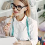 Werktisch mit Notizbuch, Taschenrechner und einer Nähmaschine