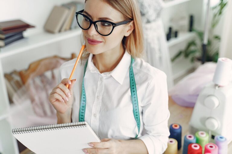 Werktisch mit Notizbuch, Taschenrechner und einer Nähmaschine
