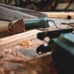 Werkbank in einem Hobbyraum mit Handwerkzeug, Absaugschlauch und Holzspänen