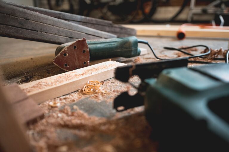 Werkbank in einem Hobbyraum mit Handwerkzeug, Absaugschlauch und Holzspänen