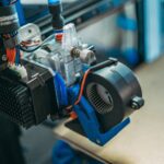 Mehrere gedruckte Kunststoffteile und ein Messschieber auf einem Werktisch