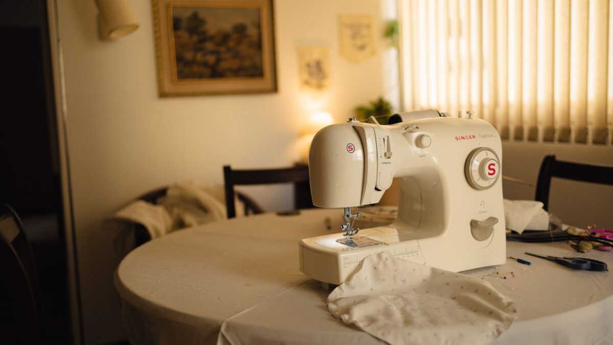 Beleuchteter Arbeitstisch mit Nähmaschine und Bastelmaterial